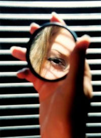 woman peers magnify glass
